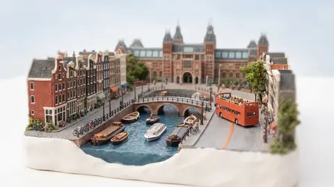 Miniature model of Amsterdam with an orange sightseeing bus